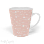 Experience the joy of sipping your favourite latte from our beautiful Wavy Daisy Latte Mug. Crafted from durable materials, this 12oz mug is perfect for everyday use and makes a lovely gift for any coffee or tea lover. Featuring a soft pink background on a white mug, with a wavy line pattern with white daisy flowers and dots throughout.