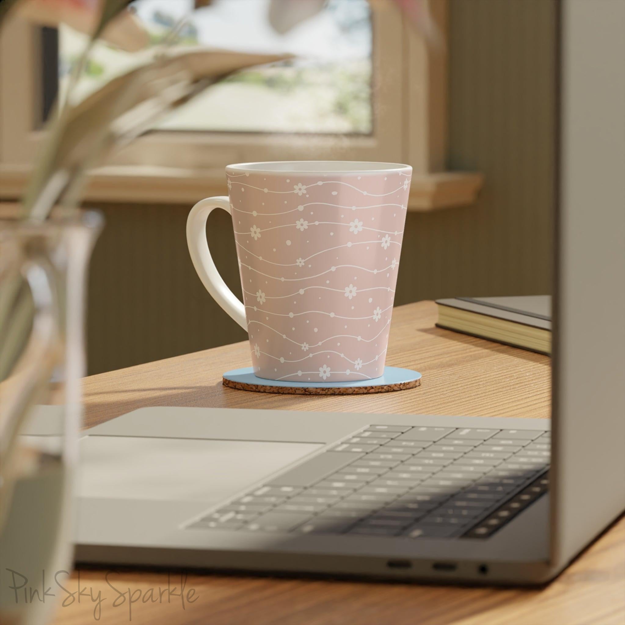 Experience the joy of sipping your favourite latte from our beautiful Wavy Daisy Latte Mug. Crafted from durable materials, this 12oz mug is perfect for everyday use and makes a lovely gift for any coffee or tea lover. Featuring a soft pink background on a white mug, with a wavy line pattern with white daisy flowers and dots throughout.