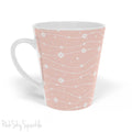 Experience the joy of sipping your favourite latte from our beautiful Wavy Daisy Latte Mug. Crafted from durable materials, this 12oz mug is perfect for everyday use and makes a lovely gift for any coffee or tea lover. Featuring a soft pink background on a white mug, with a wavy line pattern with white daisy flowers and dots throughout.