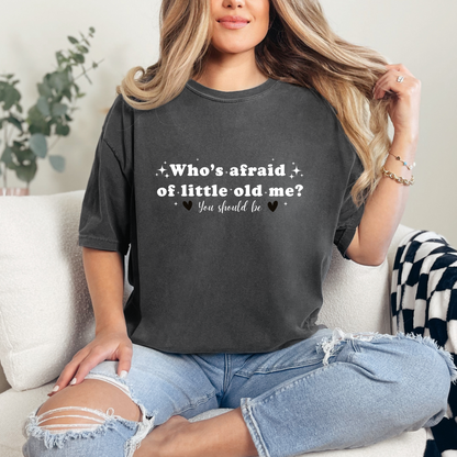 Pepper Comfort Colors Brand T-shirt with Taylor Swift inspired lyrics Who's afraid of little old me? You should be in white font with black hearts on either side of the words You should be.