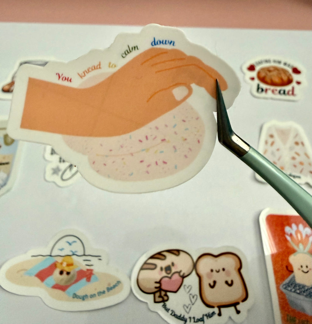 Sticker with a hand kneading a sourdough with colourful sprinkles that has the bread pun 'You knead to calm down' on it. 
